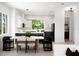 Open-concept dining room and kitchen with sleek black appliances, modern furniture, and bright natural light at 10340 2Nd N Way, St Petersburg, FL 33716