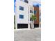 Contemporary townhome featuring multiple balconies, a black garage door, and modern architectural details at 10340 2Nd N Way, St Petersburg, FL 33716