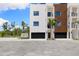 Modern townhome with a sleek black garage door, a small palm tree, and stylish exterior lighting at 10340 2Nd N Way, St Petersburg, FL 33716