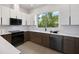 Modern kitchen boasts sleek white cabinetry, stainless steel appliances, and a large window with a scenic view at 10340 2Nd N Way, St Petersburg, FL 33716