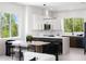 Bright, modern kitchen with white cabinets, island seating, and views of trees through the large window at 10340 2Nd N Way, St Petersburg, FL 33716