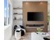 Stylish living room with modern media center, floating shelves, and comfortable black lounge chair at 10340 2Nd N Way, St Petersburg, FL 33716