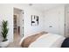 Neutral bedroom with a modern painting, warm wood accents, bright light, and open doorway to bath at 10340 2Nd N Way, St Petersburg, FL 33716
