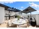 Inviting rooftop terrace with outdoor kitchen, dining area, lounge seating, and a shade umbrella at 10340 2Nd N Way, St Petersburg, FL 33716