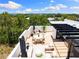 Aerial view of a beautifully furnished rooftop deck, including dining and lounge area plus an outdoor kitchen at 10340 2Nd N Way, St Petersburg, FL 33716