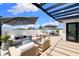 Stylish rooftop deck with modern seating, dining area, shade umbrellas, and sleek black pergola at 10340 2Nd N Way, St Petersburg, FL 33716