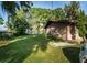 Backyard features expansive lawn, mature trees, and a glimpse of waterfront views at 10818 Land O Lakes Blvd, Land O Lakes, FL 34638