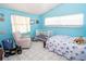 Bright bedroom with blue walls, white trim, and a crib and bed, ideal for a Bedroom at 10818 Land O Lakes Blvd, Land O Lakes, FL 34638