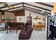 Cozy living room with brick fireplace, exposed beams, tile floors, and comfortable seating at 10818 Land O Lakes Blvd, Land O Lakes, FL 34638