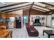 Open-concept living space with kitchen view, beamed ceiling, and tile flooring at 10818 Land O Lakes Blvd, Land O Lakes, FL 34638