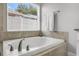 Bright bathroom showcasing a luxurious soaking tub with tile surround and modern faucet fixtures at 11324 Cypress Reserve Dr, Tampa, FL 33626