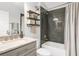 Modern bathroom featuring floating shelves, gray subway tile shower, and sleek vanity with marble countertop at 11324 Cypress Reserve Dr, Tampa, FL 33626