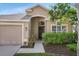 Inviting home exterior with a two-car garage, lush landscaping, and walkway at 11324 Cypress Reserve Dr, Tampa, FL 33626