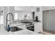 Open kitchen with a stainless steel gas range, sink, and stone countertops at 11324 Cypress Reserve Dr, Tampa, FL 33626