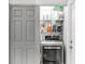Convenient laundry room with modern appliances, storage shelves, and a sliding door for space saving at 11324 Cypress Reserve Dr, Tampa, FL 33626