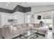 Comfortable living room featuring a sectional sofa, glass coffee table, and sliding glass doors at 11324 Cypress Reserve Dr, Tampa, FL 33626