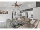 Open-concept living room with a large sectional sofa, glass coffee table, and wood-look flooring at 11324 Cypress Reserve Dr, Tampa, FL 33626