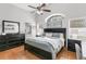 Light filled main bedroom with wood floors, vaulted ceiling, large arched window, and ensuite bathroom at 11324 Cypress Reserve Dr, Tampa, FL 33626