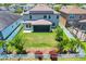 Aerial view of a two-story home showcasing a well-manicured lawn, solar panels, screened patio, and fenced yard at 11612 Sunburst Marble Rd, Riverview, FL 33579