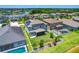 Aerial view of a community showing backyard with white fence, landscaping, lake, and houses with solar panels at 11612 Sunburst Marble Rd, Riverview, FL 33579