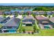 Aerial view showcasing backyard with white fence, mature landscaping, screened patio, and neighborhood lake at 11612 Sunburst Marble Rd, Riverview, FL 33579