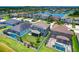 Aerial view highlighting a home's backyard, white fence, landscaping, screened patio, and neighborhood lake at 11612 Sunburst Marble Rd, Riverview, FL 33579