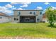 Large backyard showcases a covered patio, expansive green space, and a secure white perimeter fence at 11612 Sunburst Marble Rd, Riverview, FL 33579