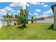 Lush backyard with mature trees, green lawn, and white fencing, creating a serene outdoor space at 11612 Sunburst Marble Rd, Riverview, FL 33579