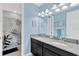 Well-lit bathroom featuring double sinks, black cabinetry, granite countertops, and a shower with stylish shower curtain at 11612 Sunburst Marble Rd, Riverview, FL 33579