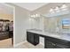 Bright bathroom with double sinks, granite countertops, black cabinets, and a luxurious shower in a neutral color palette at 11612 Sunburst Marble Rd, Riverview, FL 33579