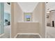Bright hallway with neutral colors and a view to other rooms; the space is carpeted and well-lit with a small window at 11612 Sunburst Marble Rd, Riverview, FL 33579