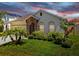Charming single-story home boasts stone accents, arched entryway, and lush green lawn with mature tropical landscaping at 11623 Tetrafin Dr, Riverview, FL 33579