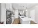 Open-concept kitchen with stainless appliances, gray cabinets, island, and pendant lights at 11623 Tetrafin Dr, Riverview, FL 33579
