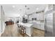 Open kitchen features an island with seating, stainless steel appliances, and hardwood floors at 11623 Tetrafin Dr, Riverview, FL 33579
