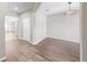 Neutral room with hardwood floors, white walls, and a modern light fixture at 11623 Tetrafin Dr, Riverview, FL 33579