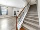 Carpeted staircase with wood and iron banister adjacent to a modern kitchen at 11623 Tetrafin Dr, Riverview, FL 33579