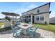 Cozy backyard with a brick patio, fire pit table, and outdoor seating near the screened-in lanai at 11726 Sunburst Marble Rd, Riverview, FL 33579
