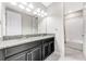 Bathroom featuring double sinks with granite countertops and black cabinets plus a shower/tub at 11726 Sunburst Marble Rd, Riverview, FL 33579