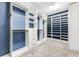 Walk-in closet with custom white shelves and drawers with a blue accent wall at 11726 Sunburst Marble Rd, Riverview, FL 33579