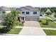 Two-story home with a three-car garage, paver driveway, and landscaped front yard at 11726 Sunburst Marble Rd, Riverview, FL 33579
