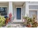 Inviting front entrance featuring a stylish blue door, decorative plants, and a paver walkway at 11726 Sunburst Marble Rd, Riverview, FL 33579