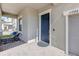 Welcoming front door with an elegant blue finish, charming decor, and covered porch with brick flooring at 11726 Sunburst Marble Rd, Riverview, FL 33579