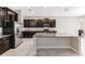 This open kitchen features dark cabinets, granite countertops, stainless steel appliances, and an island at 11726 Sunburst Marble Rd, Riverview, FL 33579
