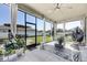 Enclosed lanai with neutral color palette, ceiling fan, and view of the outdoor living space at 11726 Sunburst Marble Rd, Riverview, FL 33579