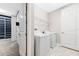 Bright laundry room with white washer and dryer, plus wire shelving for storage at 11726 Sunburst Marble Rd, Riverview, FL 33579