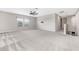 Open living room with plush carpet, ceiling fan, and natural light at 11726 Sunburst Marble Rd, Riverview, FL 33579