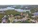 An aerial view shows waterfront community situated among lush greenery and a large lake at 1175 San Carlos Ne Ave, St Petersburg, FL 33702