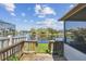 View from wooden back deck with railings overlooking the lake and screened in porch on a sunny day at 1175 San Carlos Ne Ave, St Petersburg, FL 33702