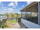 View from wooden back deck with railings overlooking the lake and screened in porch on a sunny day at 1175 San Carlos Ne Ave, St Petersburg, FL 33702