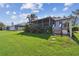 Manicured backyard with a screened porch, tropical foliage, and a well maintained green lawn at 1175 San Carlos Ne Ave, St Petersburg, FL 33702